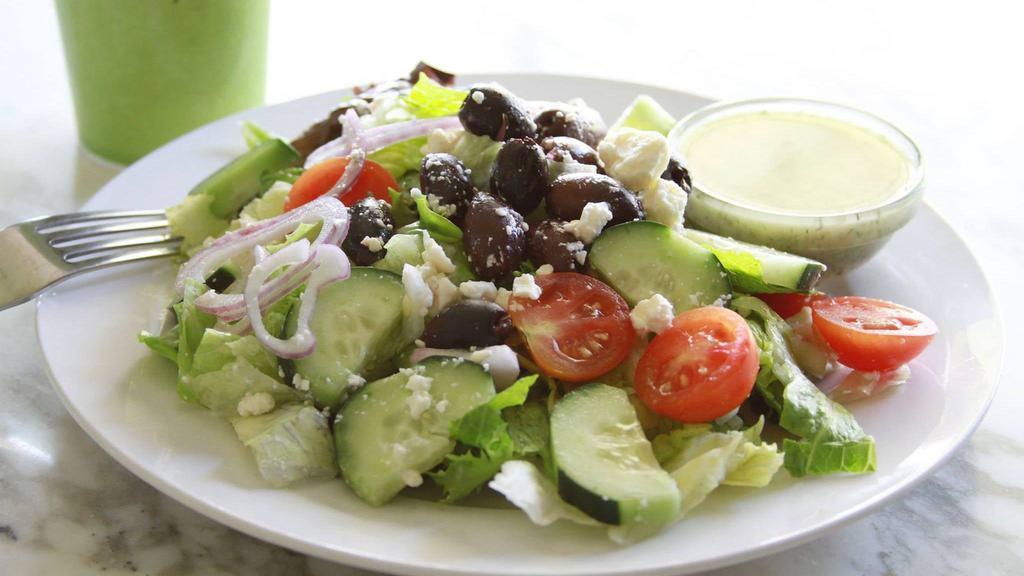 Greek Salad · Iceberg and romaine lettuce, Feta cheese, tomatoes, cucumbers, red onions, Greek olives, with our lemon-olive oil dressing on the side.