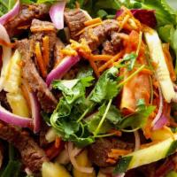 Beef Salad · Marinated grilled beef sliced placed atop mixed greens, cucumber, tomato, onions and finishe...