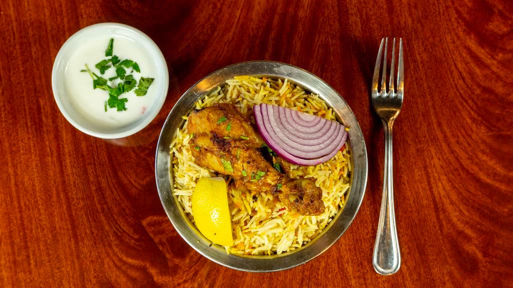 Chicken Biryani · Long-grained rice (basmati) flavored  cooked with fragrant saffron, Aroma spices, fresh mint , cilantro and layered with Bone Chicken.