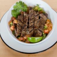 Steak Tazon · White rice, black beans, tomatoes, lettuce, sopito sauce with steak. Served in a sustainable...