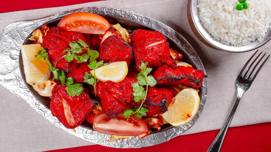 Chicken Tandoori · Bone in chicken marinated in yogurt himalayan herbs and spices grilled in the tandoor oven and serve sizzling with sautéed onions, bell pepper, cabbage and carrot.