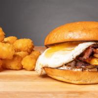 The Sunnyside Breakfast Sandwich · Fried egg, breakfast sausage, bacon, tater tots, cheddar cheese and sriracha aioli on a toas...