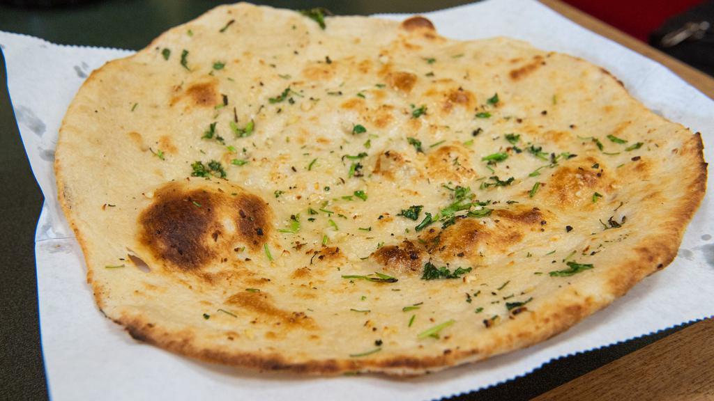 Garlic Nan · Leavened oven-baked flat bread with sprinkled garlic.