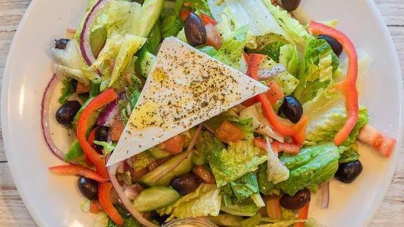 Greek Salad · A vegetarian mix of romaine heart, tomatoes, cucumbers, red onions, and red bell peppers, tossed with fresh squeezed lemon juice and extra virgin olive oil, topped with feta cheese and Greek olives.