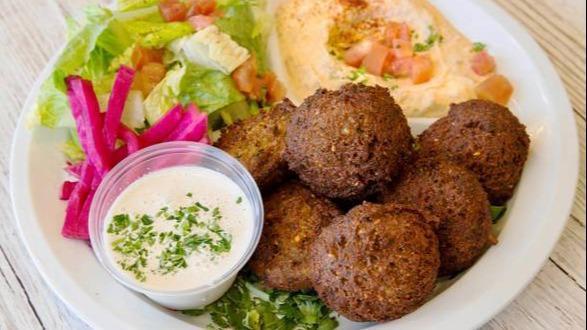 Falafel Plate · 7 falafels with a side of hummus, green salad, and pickled turnips. Served with tahini sauce and pita bread.