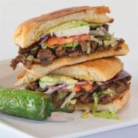 Torta · Telera bread toated served with beans, your choice of meat  topped with lettuce, tomatoes, a...