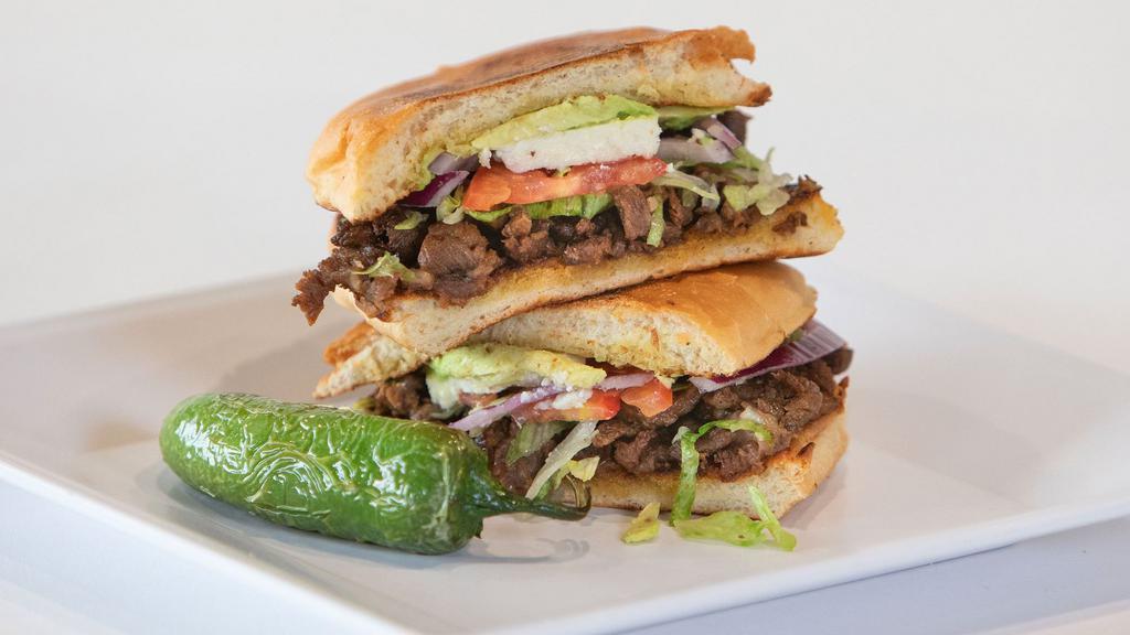 Torta · Telera toasted with beans, your choice of meat  topped with lettuce, tomatoes, avocado, purple onion, queso fresco, and mayo.