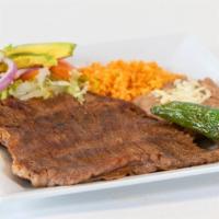 Ranchera A La Plancha · Flap steak on the grill  with rice & beans and a side salad.