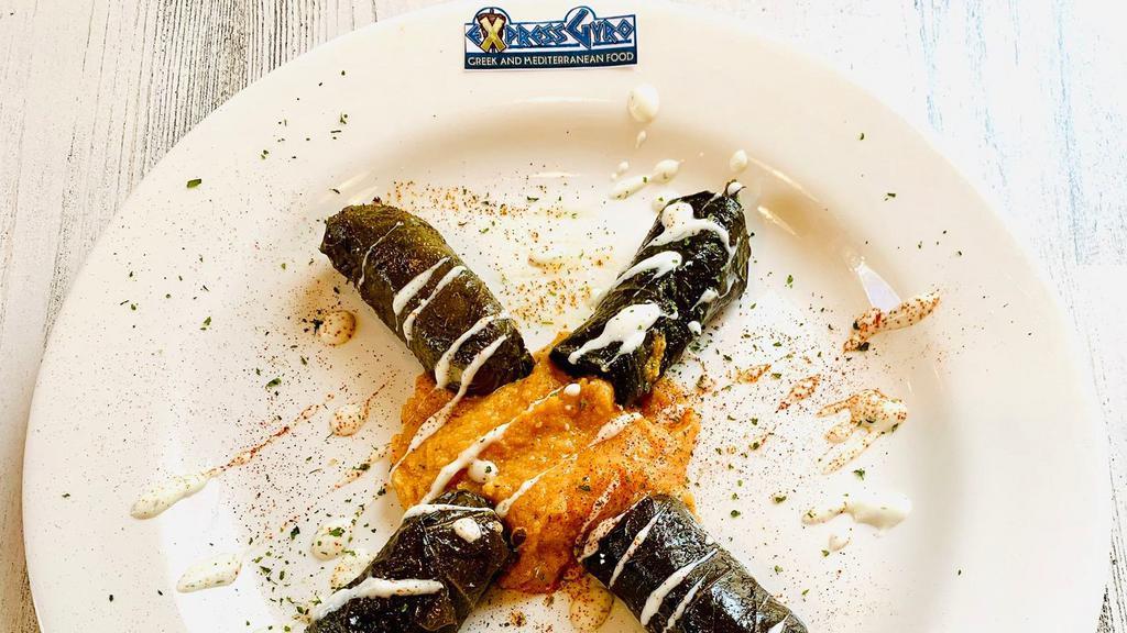 Dolmas (4 Pcs.) · Gluten-free. Grape leaves stuffed with rice and spices. It comes with a choice of starter and tzatziki.