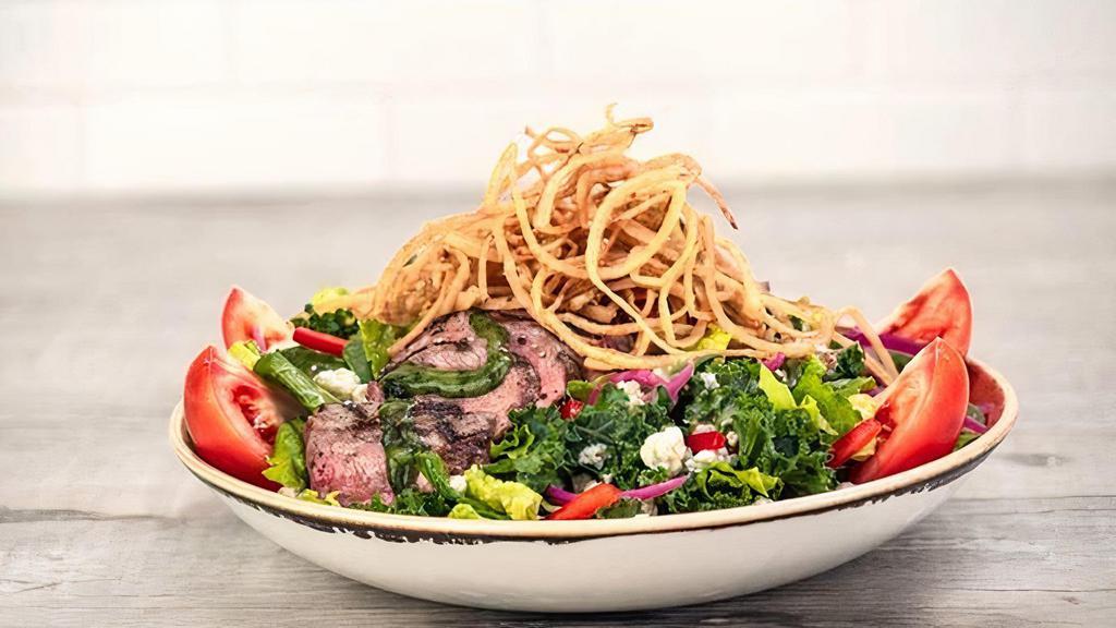 Steak Salad · 8 oz. grilled steak on a bed of fresh mixed greens tossed in a blue cheese vinaigrette, with pickled red onions, red peppers, and Roma tomatoes, finished with crispy shoestring onions and blue cheese crumbles.