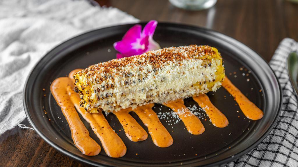 Elote / Corn · Elote entero al grill, servido con mayonesa, queso fresco y chile piquin. / Whole grilled corn, served with mayonnaise, fresh cheese and chili pepper.