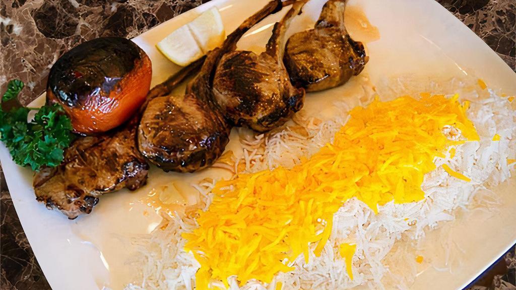 Lamb Chops · Marinated lamb chops grilled served with basmati rice with saffron, grilled tomato, and Anaheim pepper.