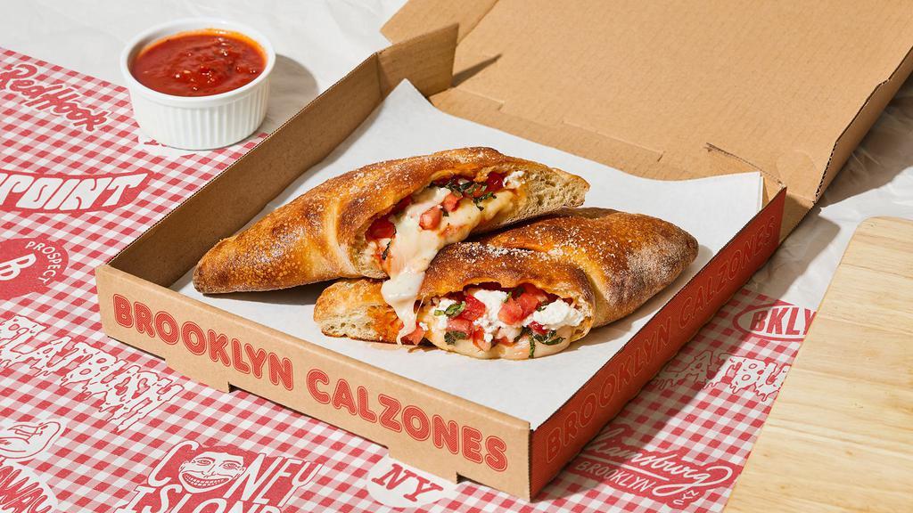 The L Train Calzone · Calzone with creamy ricotta, parmesan cheese, melted mozzarella, tomato, basil, and a side of marinara. (v)