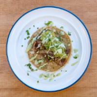Carnitas Street Taco · Carnitas, cilantro sauce, onions, cilantro, and guacamole on corn tortillas.