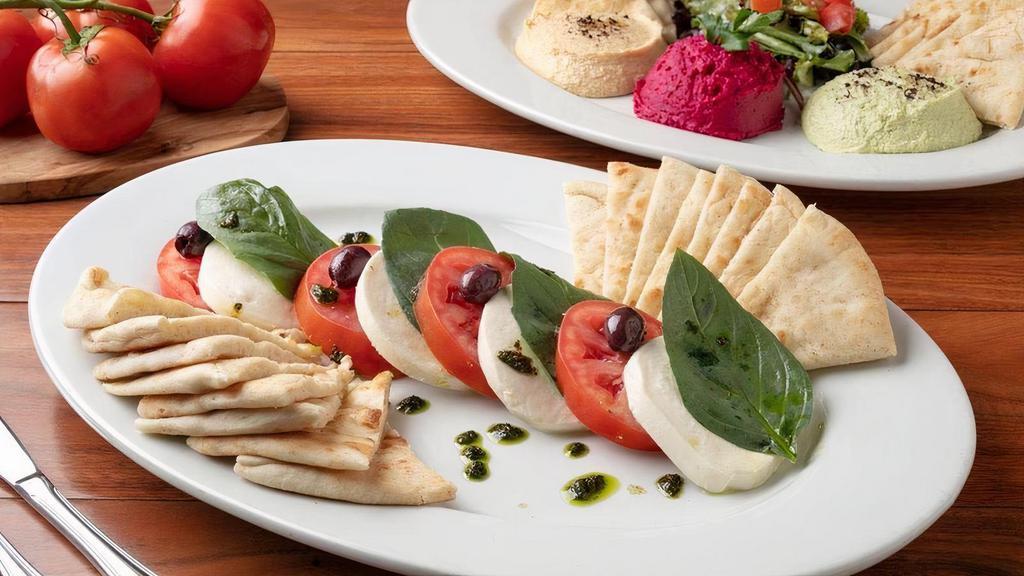 Caprese Appetizer · 4 Slices of Fresh Mozzarella, Roma Tomatoes, Fresh Basil, and Kalamata Olives Drizzled With Freshly Made Pesto.