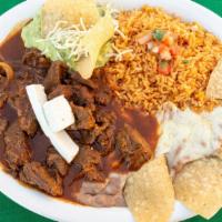 Plato De Chile Colorado (Beef) · Cube choice top sirloin simmered in our delicious guajillo sauce. Garnished with panela chee...