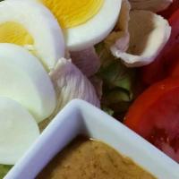 Salad Kaak (Thai Salad) · Chicken or tofu and boiled egg served over mixed greens, tomatoes, carrots, onions and cucum...