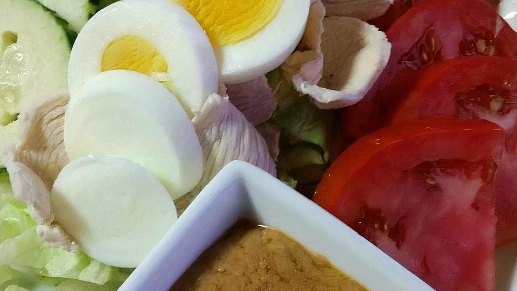 Salad Kaak (Thai Salad) · Chicken or tofu and boiled egg served over mixed greens, tomatoes, carrots, onions and cucumber. Dressing: peanut or house dressing.
