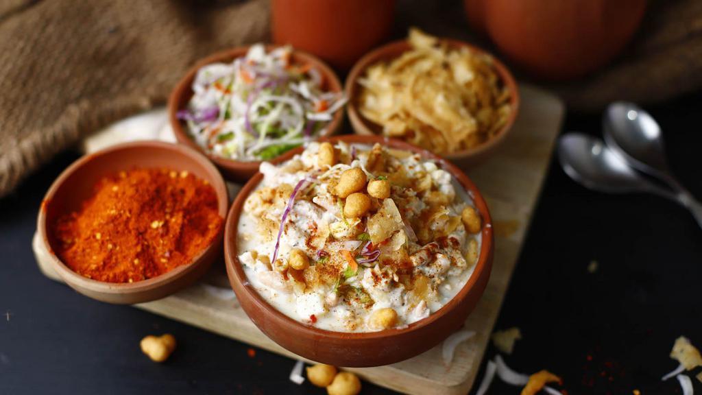Papri Chaat · Crisp flatbreads topped with yogurt, potatoes, onions, tangy & spicy chutney topped with crispy sev & cilantro.