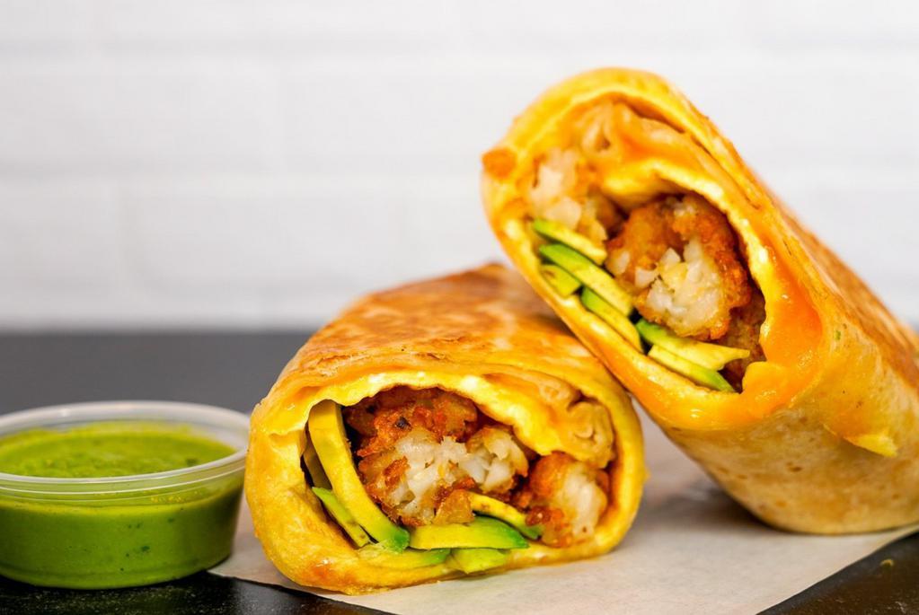 Avocado, Egg & Cheddar Breakfast Burrito · 3 fresh cracked, cage-free scrambled eggs, melted Cheddar cheese, avocado salsa verde, fresh avocado, and crispy potato tots wrapped in a toasted 12” flour tortilla. Comes with avocado salsa verde side.