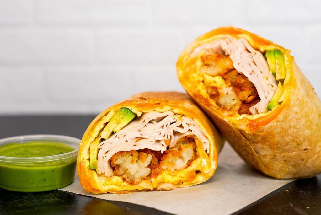 Smoked Turkey, Avocado, Egg, & Cheddar Breakfast Burrito  · 3 fresh cracked, cage-free scrambled eggs, melted Cheddar cheese, sliced smoked deli turkey, fresh avocado, and crispy potato tots wrapped in a toasted 12” flour tortilla. Comes with avocado salsa verde side