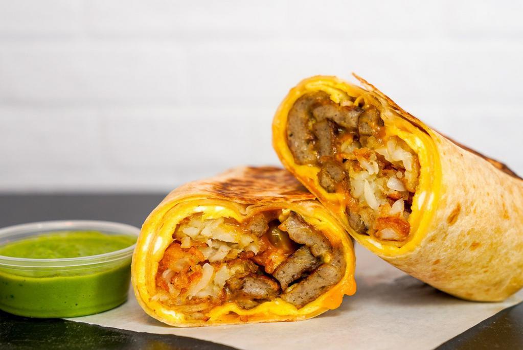 Sausage, Egg & Cheddar Breakfast Burrito · 3 fresh cracked, cage-free scrambled eggs, melted Cheddar cheese, seared pork sausage patties, and crispy potato tots wrapped in a toasted 12” flour tortilla. Comes with avocado salsa verde side.