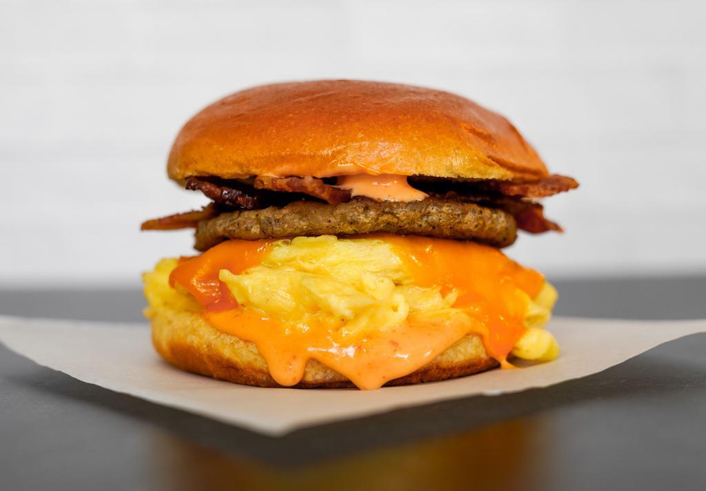 Brioche, Bacon, Sausage, Egg, & Cheddar Sandwich · 2 scrambled eggs, melted Cheddar cheese, smoked bacon, breakfast sausage, and Sriracha aioli on a warm brioche bun.