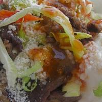 Sope Con Carne · Deep fried corn meal that's topped with your choice of meat, beans, lettuce, tomato, sour cr...
