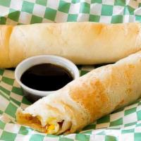 Pancake Roll Ups · Scrambled eggs and bacon wrapped in two large pancakes. Served with bacon maple syrup.