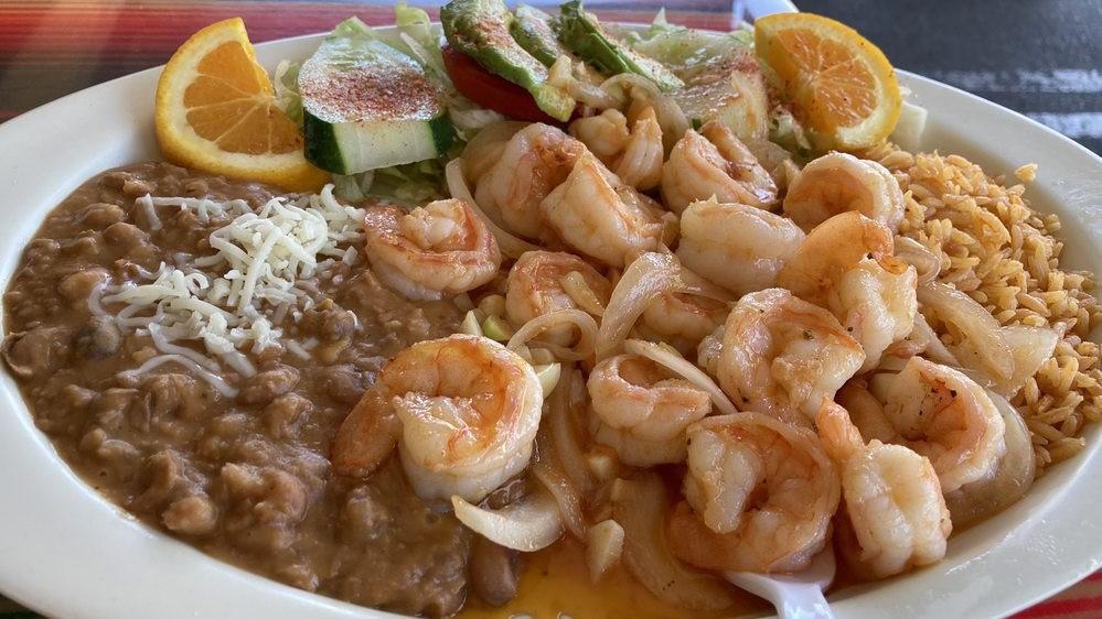 Camarones Al Mojo De Ajo · Garlic prawns. Includes rice, beans, cucumber, avocado, lettuce, tomatoes, and tortillas.