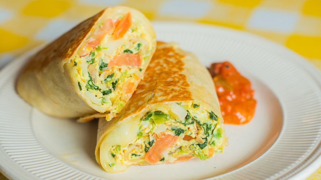Veggie Breakfast Burrito · Scrambled eggs, grilled tomato, grilled mushrooms, grilled onions, sautéed spinach, home fries, and swiss cheese wrapped in a flour tortilla. Served with a side of salsa.