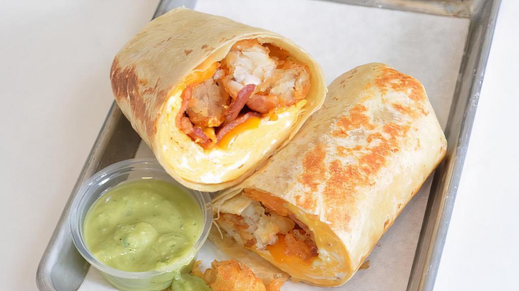 Bacon, Egg And Cheddar Burrito · 3 fresh cracked cage-free scrambled eggs, melted Cheddar cheese, smokey bacon, crispy potato tots wrapped in a toasted 12” flour tortilla and side of avocado salsa verde