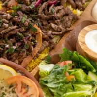 Beef Shawarma · Marinated grilled beef strips topped with red onions, parsley, sumac, and tahini sauce. Come...