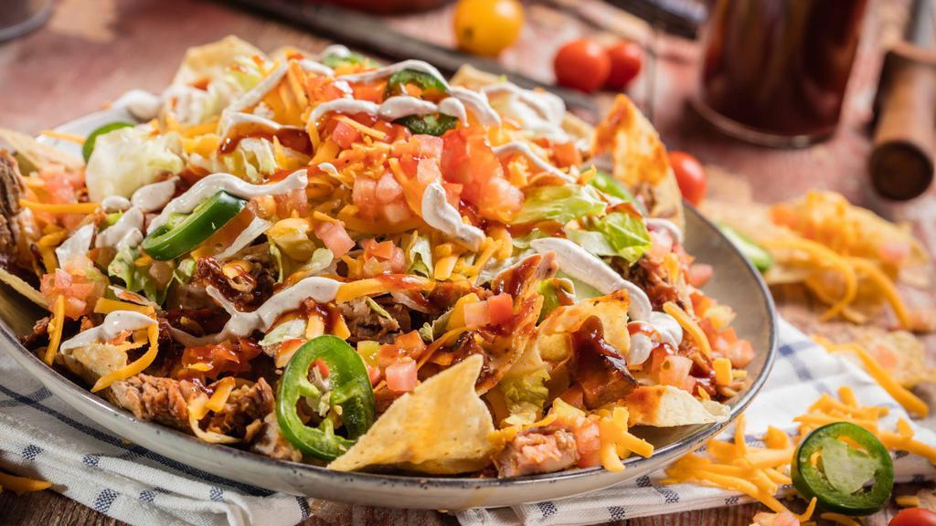 Famous Nachos Appetizer · Tortilla chips layered with cheddar cheese, lettuce, tomato, Wilbur Beans, jalapeños, seasoned sour cream, Rich & Sassy® and choice of Texas Beef Brisket, Georgia Chopped Pork or Barbeque Pulled Chicken.
