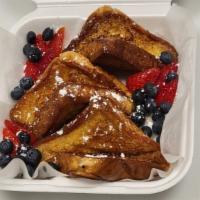 The Best French Toast · French Toast with strawberry, blueberry, powdered sugar and syrup on top.