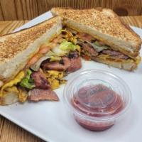 Smoked Sausage Sandwich · Smoked Sausage, smashed eggs, cheese, sautéed onions, lettuce, tomatoes. Served on Texas Toa...
