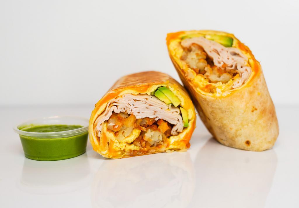 Smoked Turkey, Avocado, Egg, & Cheddar Breakfast Burrito  · 3 fresh cracked, cage-free scrambled eggs, melted Cheddar cheese, sliced smoked deli turkey, fresh avocado, and crispy potato tots wrapped in a toasted 12” flour tortilla. Comes with avocado salsa verde side