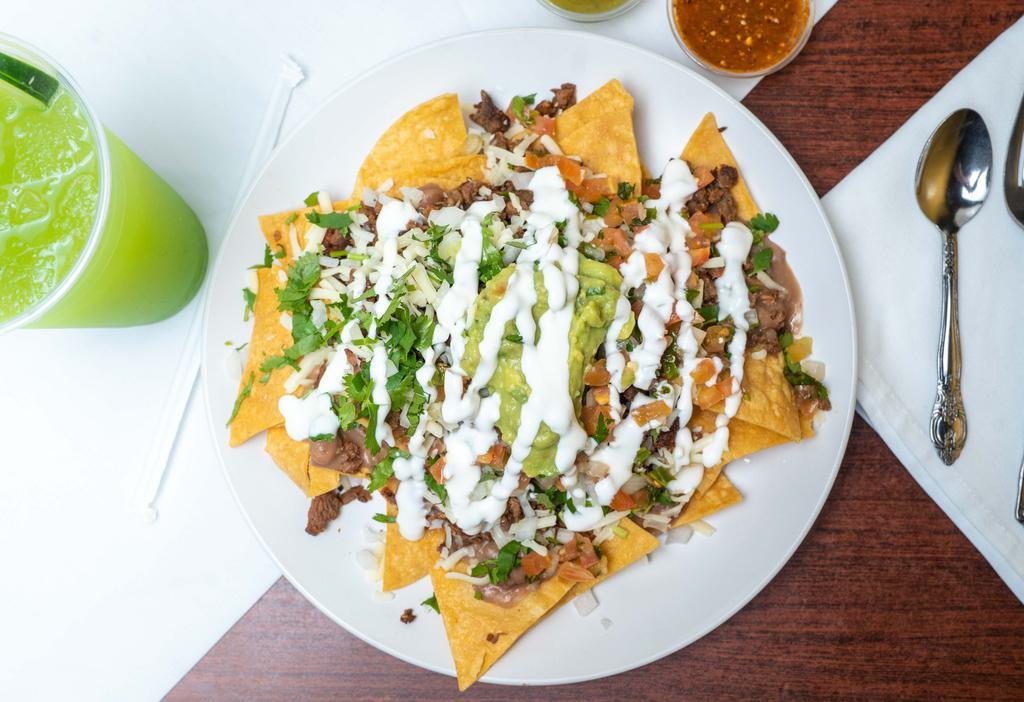 Nachos · In house tortilla chips topped with beans, cheese, pico de gallo, guacamole, sour cream and your choice of meat.
