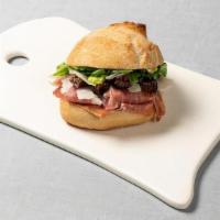 Prosciutto Manchego Sandwich · with dried figs and mustard butter on a French roll.  Modify your order and add a mixed gree...