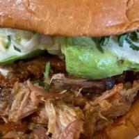 Pulled Pork Bbq Sandwich · Pulled pork with pickled red onions, cilantro, pineapple coleslaw, and bbq sauce on a toaste...