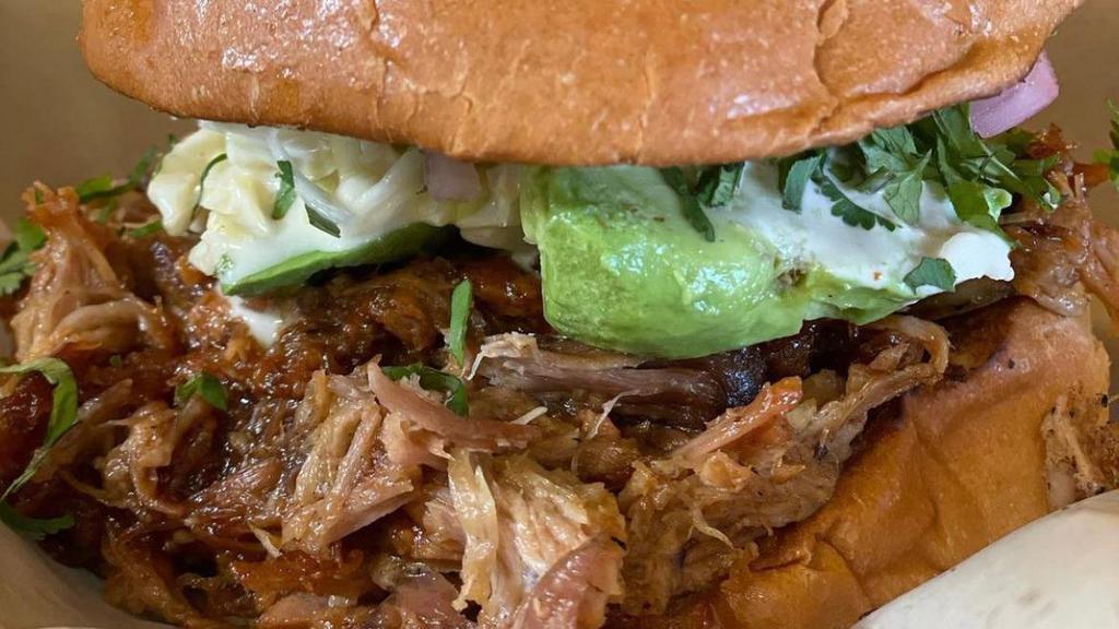 Pulled Pork Bbq Sandwich · Pulled pork with pickled red onions, cilantro, pineapple coleslaw, and bbq sauce on a toasted brioche bun.