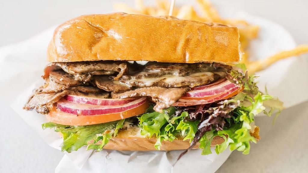 Steak Sandwich · Sliced tri-tip, melted white cheddar cheese, mixed greens, tomatoes, onions, and mayo, served on toasted garlic bread.