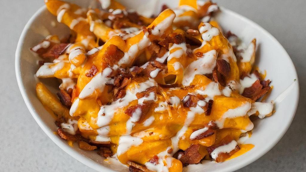 House Fries · Crispy cut fries topped with melted cheddar cheese, bacon, and our homemade Creamy Ranch Dressing