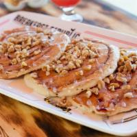 Cinnamon Roll Pancakes · Contains nuts. Topped with walnuts, cinnamon frosting and powdered sugar.