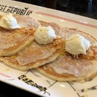 Lemon Coconut Pancakes · Topped with lemon zest glaze, roasted coconut flakes, whipped butter and powdered sugar.
