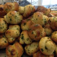 One Dozen Garlic Knots · Drizzled with olive oil, garlic and Italian parsley served with a side of homemade marinara ...