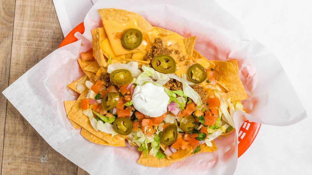 Nachos · refried beans, guacamole, cheese, salsa, sour cream. Add your choice of meat for an additional charge.