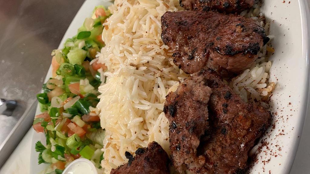 Beef Kabob · Chunks of beef marinated with Afghan spices. Grilled to perfection served with naan rice and salad (green chatni white sauce and a side of beans).