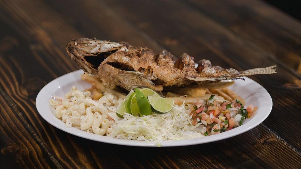 Mojarra Frita · Whole deep-fried mojarra fish (tilapia) served with a side of fries, macaroni crab salad, cabbage, & Mexican salad.