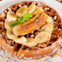 Banana Walnut Waffle · Our classic Belgian waffle with fresh bananas and caramel sauce topped with a bruleed banana...